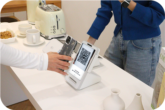 카페에 설치된 팁포스를 통해 고객이 QR결제를 진행하는 모습